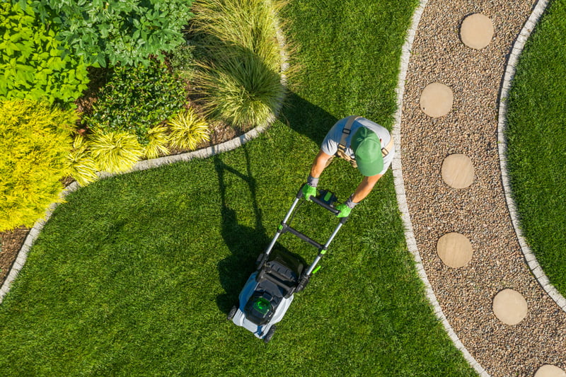 gardener mowing backyard garden grass aerial view